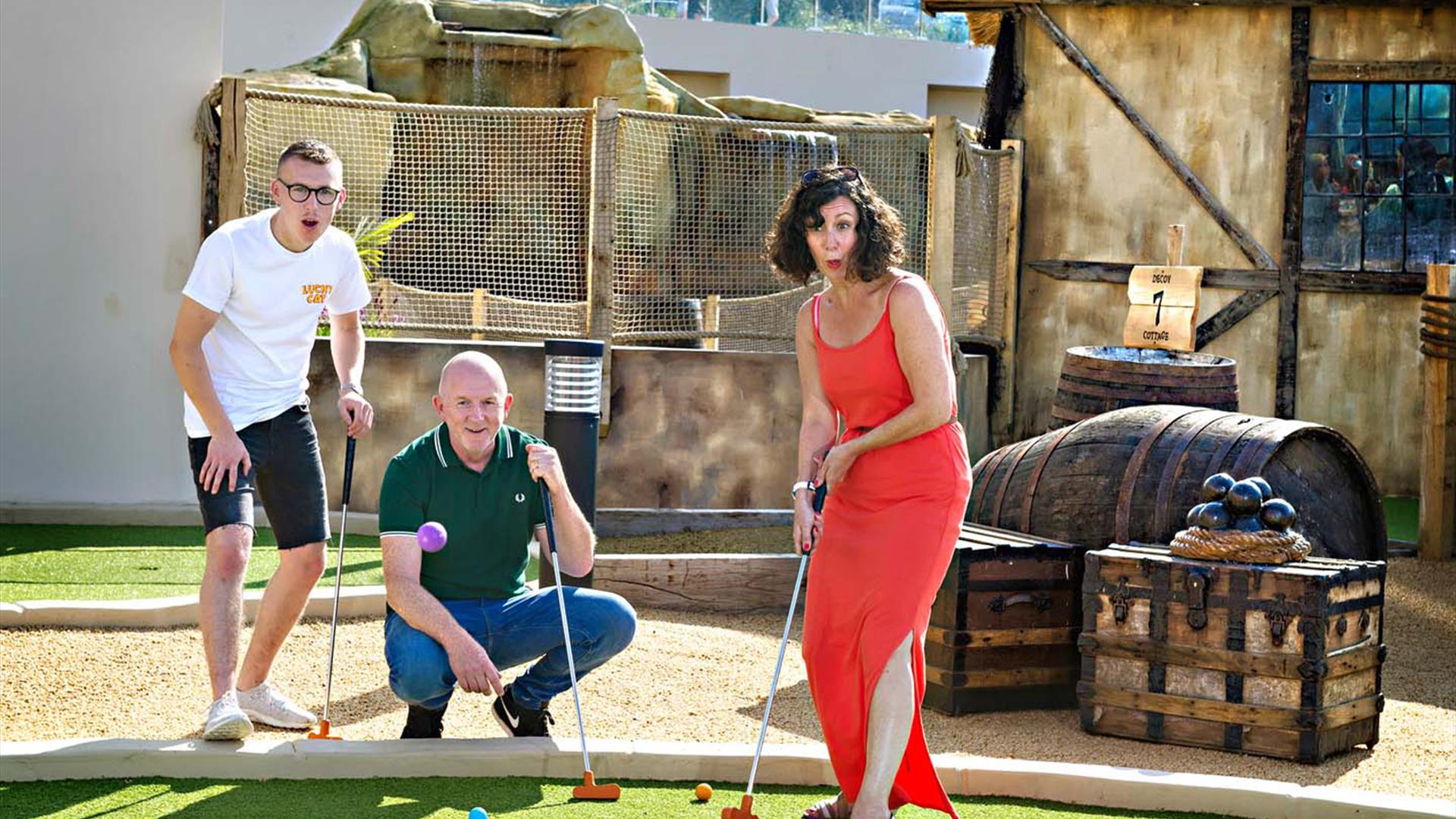 Family putting at a Bournemouth crazy golf venue next to the seaside