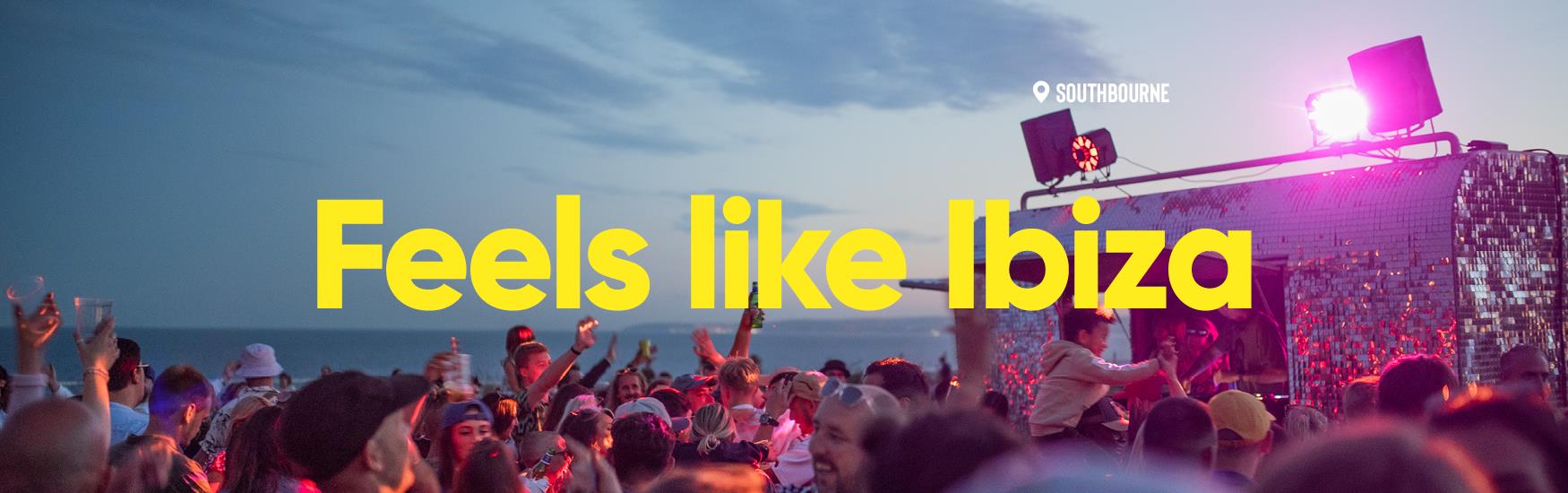 People dancing at a concert at a beach in Bournemouth with text that reads "feels like ibiza"