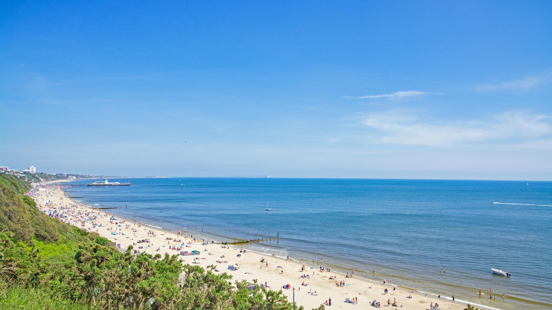 Shot looking over Bournemouth beach with visitors sunning themselves in the summer sun