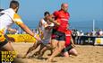 Men playing rugby on the beach