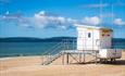 RNLI lifeguard tower overlooking Durley Chines sandy beach and blue sea