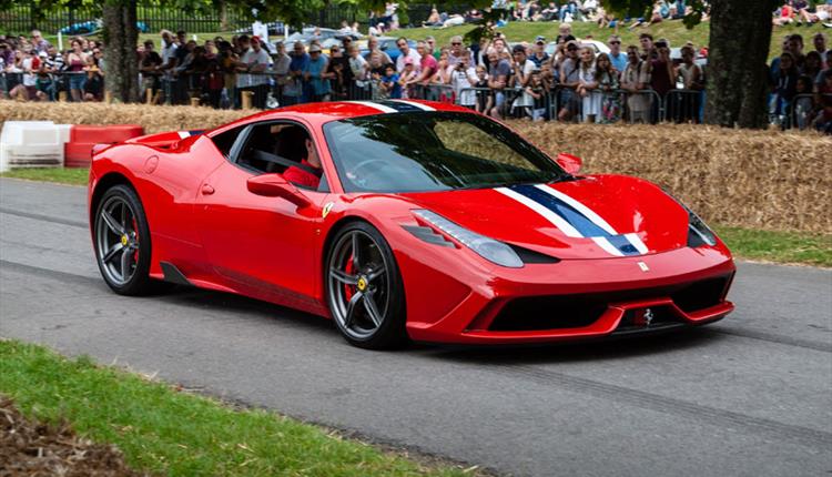 Red supercar pulling up at car event