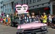 Pink cadillac leading the gay pride parade around the streets of Bournemouth on a beautiful day