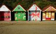 Four of the Christmas beach huts basking in the sun on Bournemouth seafront