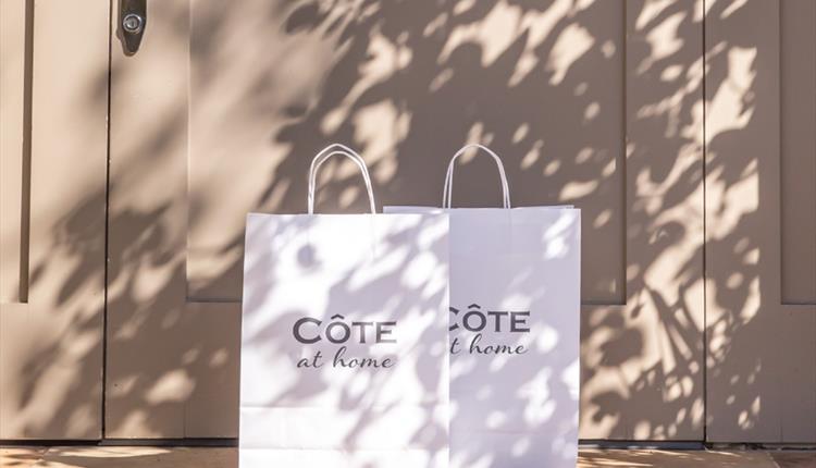 Cote bags with Cote at Home written on them outside front door