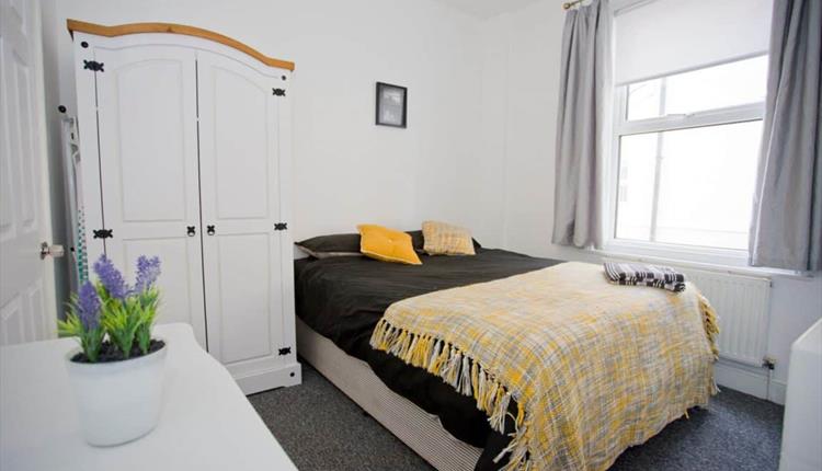 Fresh modern bedroom with yellow pillows and throw