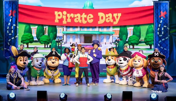 PAW Patrol Live! people dressed up as paw patrol dogs with other actors on stage below the banner 'Pirate Day'