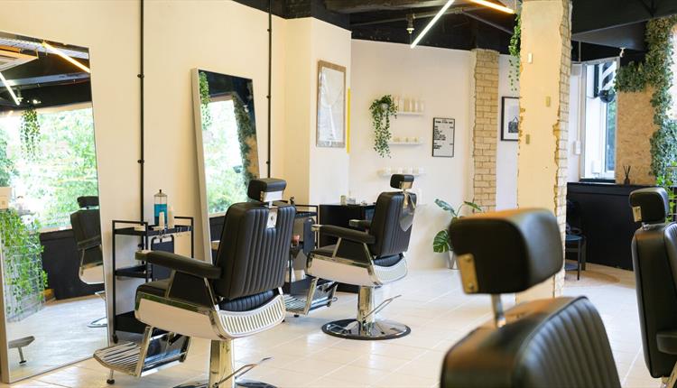 Inside of a barber shop with chairs and mirrors