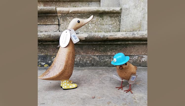 Two wooden ducks on a stone step
