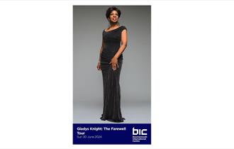 Gladys Knight in a black floor length dress smiling