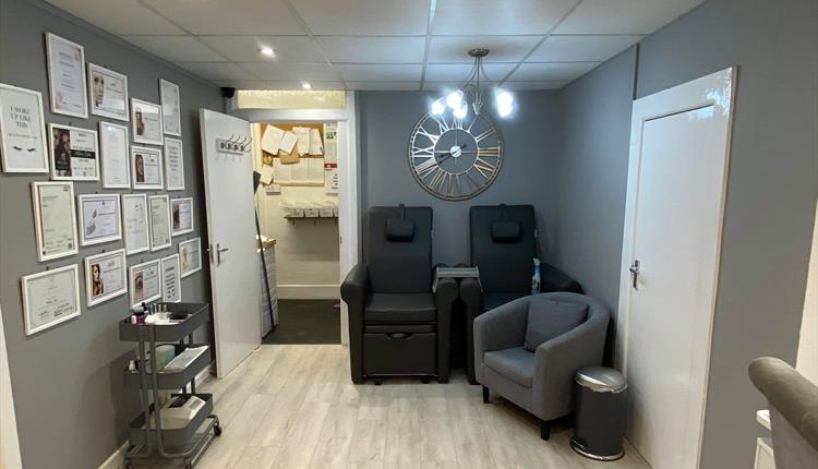 Grey interior with bright white lighting and a fashionable clock on the wall.