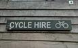 Wooden sign that reads 'cycle hire'.