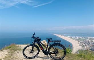 Electronic bike on a cliff overlooking the sea and beach