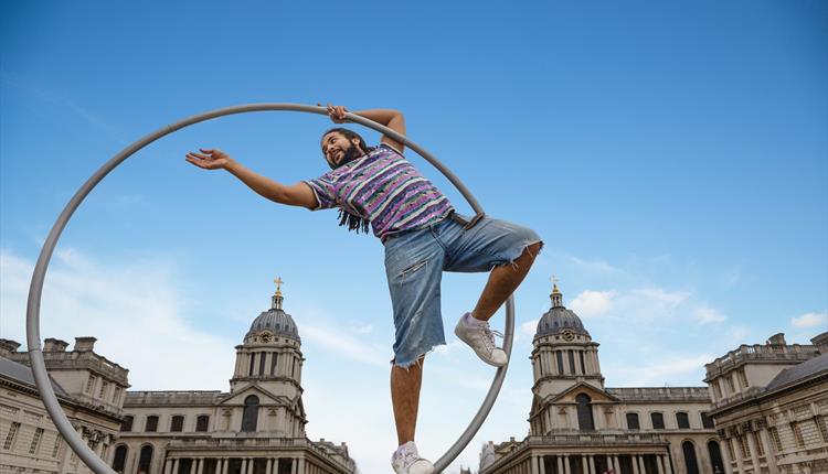 Man standing in a large hoop reaching out