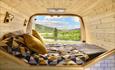 Image of inside a panelled wooden camper looking out to the great outdoors.