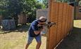 Man hiding behind a fence with his laser gun