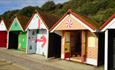 Side shot of the colourful wrapped beach huts dressed up in Christmas decorations