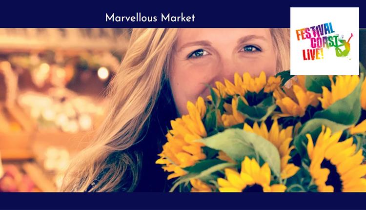 Woman smiling with sunflowers in her hands and food market in the background