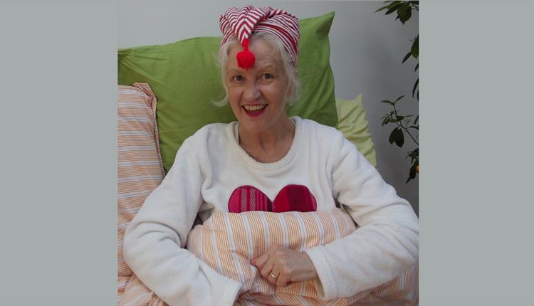 Michele O’Brien wearing a stripey night cap ready to read Sunday night Bedtime Stories from her isolation inspiration station.