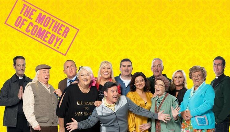 All of the cast in a line with a yellow background