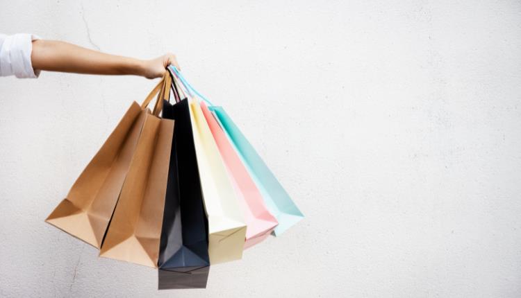generic photo of an arm holding different coloured shopping bags