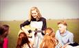 close up of Maria sat singing with the Von Trapp children in the sound of music musical