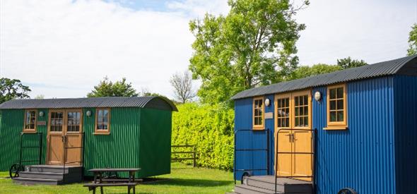 two Sheppard huts, green and blue