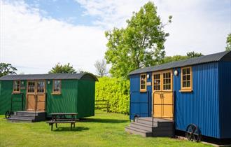 two Sheppard huts, green and blue