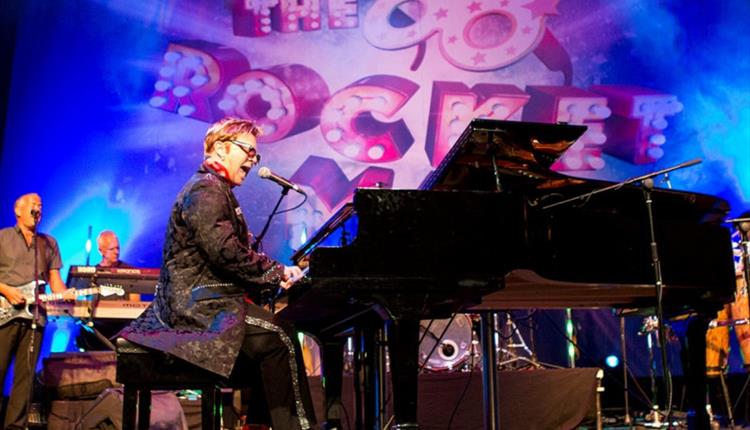 image of Elton John impersonator on stage playing piano