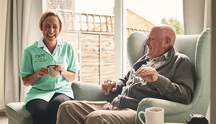 Nurse with older gentleman drinking tea