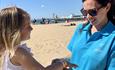 Seafront ranger placing wristband on child at Bournemouth beach