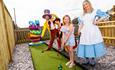 mini golf with staff dresssed up and small girl on course