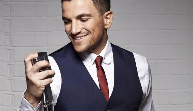 Peter Andre standing at a microphone