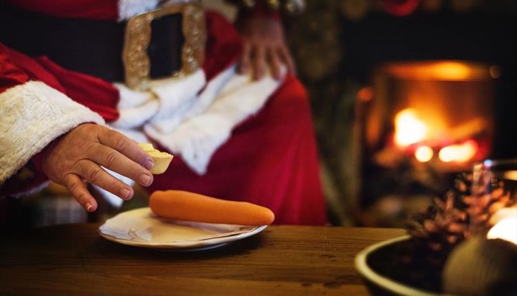 Santa taking a mince pie from a plate