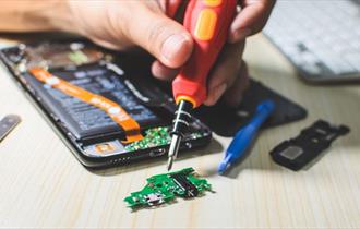 Someone repairing a phone with screwdriver