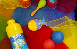 Brightly coloured scarves, noisy rattles and bubble mix for a fun Wriggle and Rhyme time.