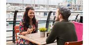couple enjoying a drink on the Brighton Marina waterfront