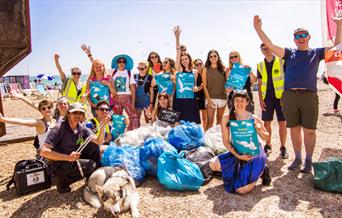 Group of people on beach with bin bags and posters