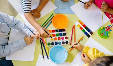 Children using pencils paint and colourful paint