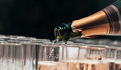 Champagne bottle pouring into glasses