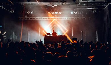 DJ performing in front of a crowd in a club