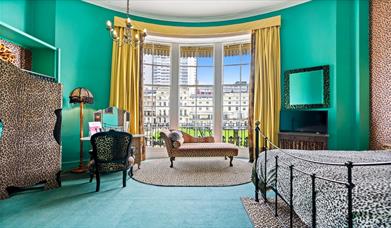 Betties Boudoir room at Hotel Pelirocco showing a green room with a leopard print bedcover and wall hangings.