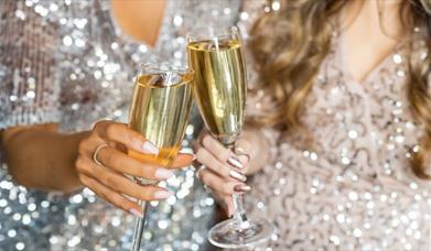 Celebrating the festive season at The Mercure Brighton Seafront, two glasses of Champagne in a cheers.