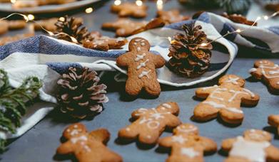Gingerbread men surrounded with pinecones and string lights