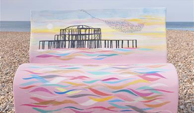 Bench sculpture on the pebbles painted with an image of Brighton' West Pier