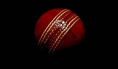 Red cricket ball on dark background