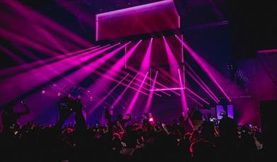 Purple strobe lights in active crowd