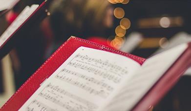 Carolers holding music song books