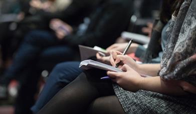 People taking notes at a lecture