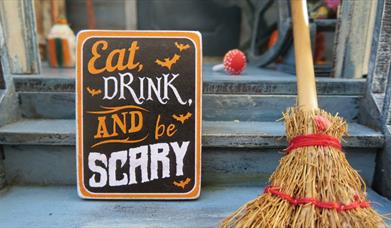 Eat drink and be scary sign with wooden broom